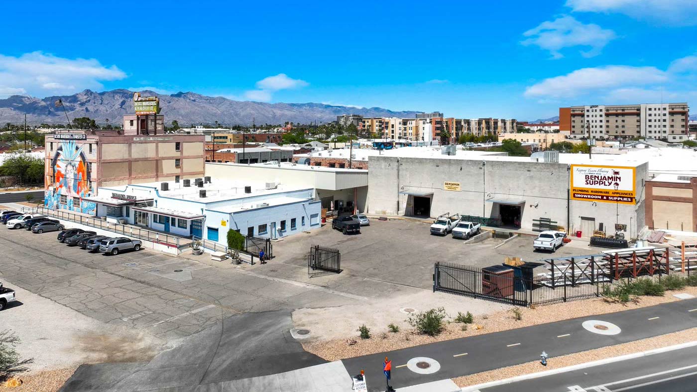 Aerial view of a parking lot with a building visible in the background, showcasing the layout and surroundings.