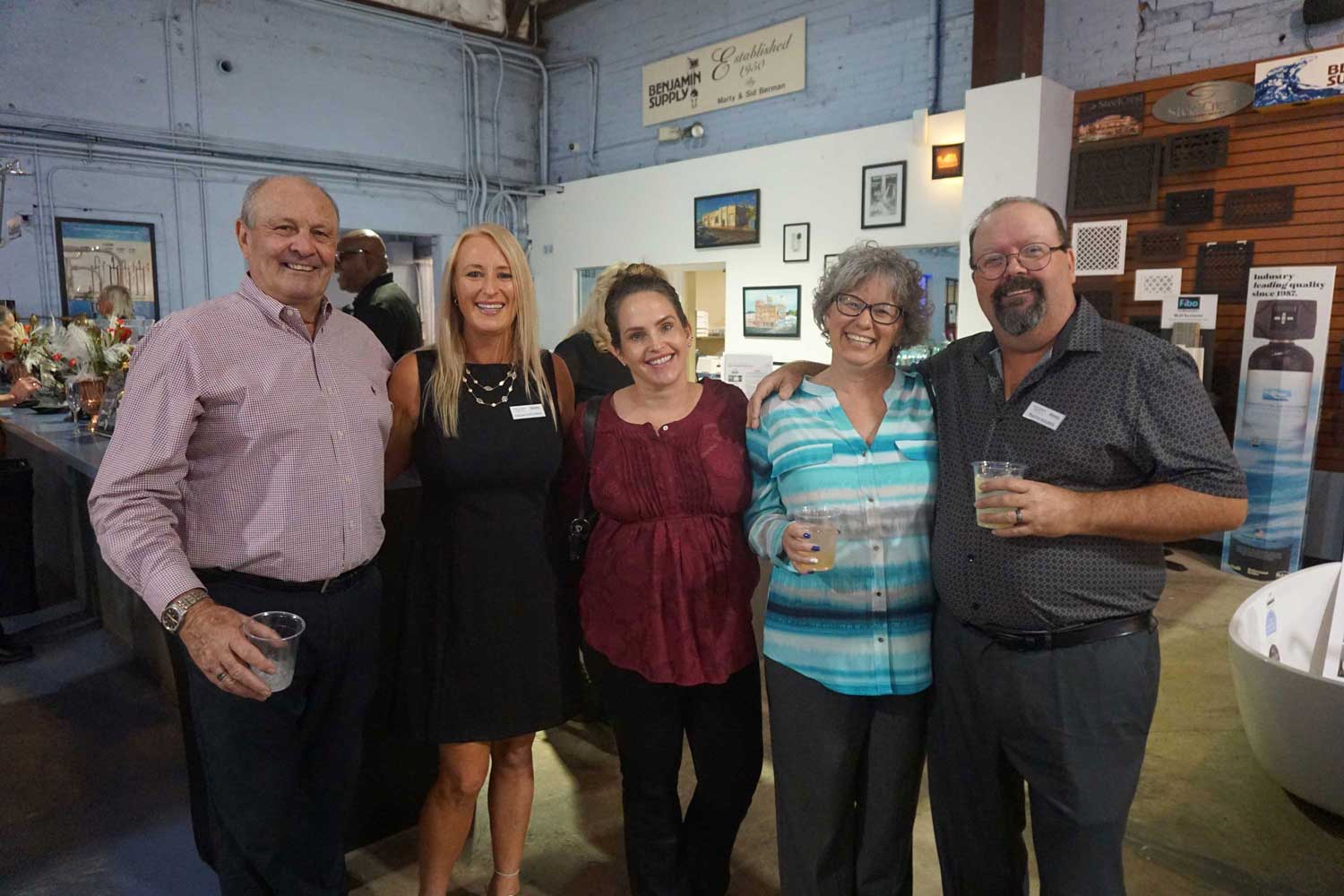 Group of five people posing together in the showroom.