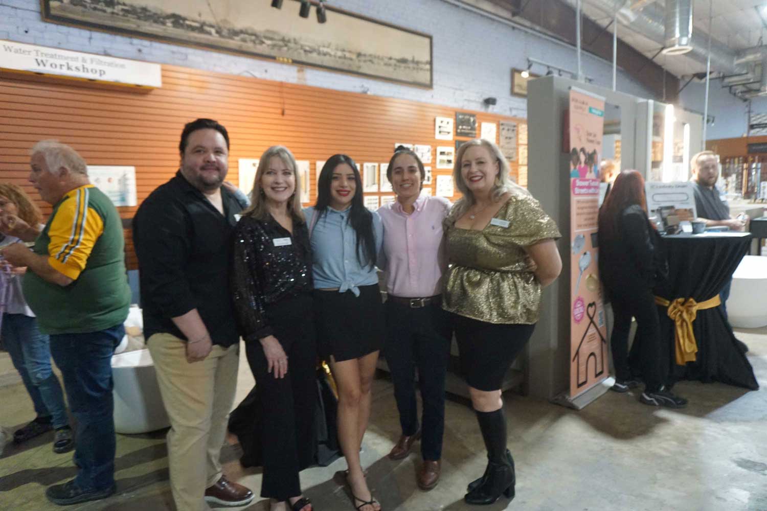 Group of five people posing together in the showroom.