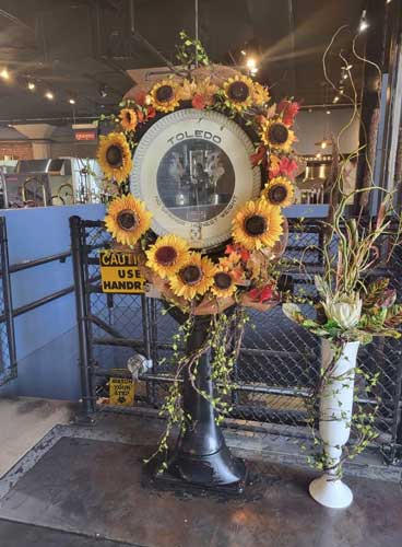 Vintage Toledo scale decorated with a sunflower wreath and autumn floral arrangement.