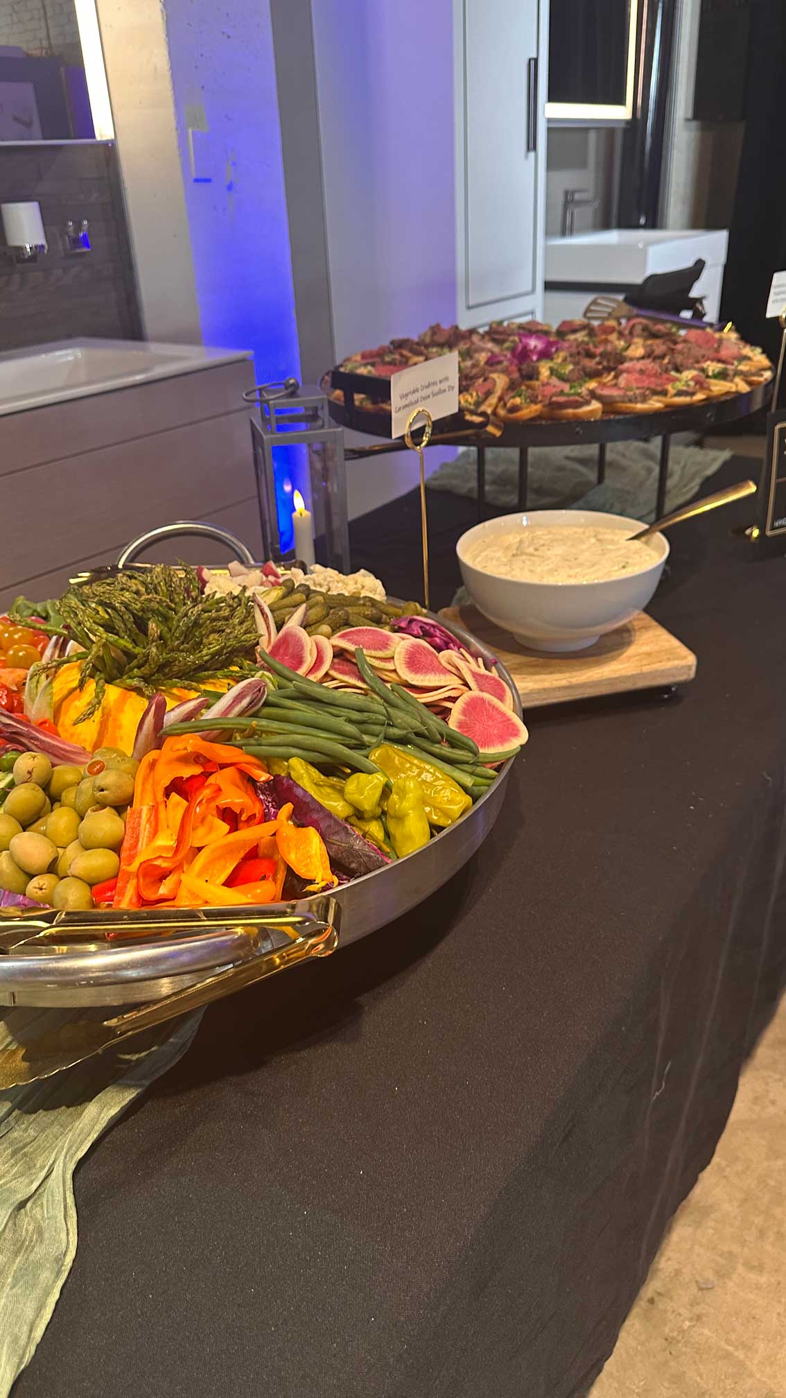 Large bowl of dip and appetizer platters on a buffet table.