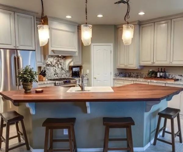 Modern kitchen illuminated by stylish pendant lights, enhancing the space with warmth and elegance.