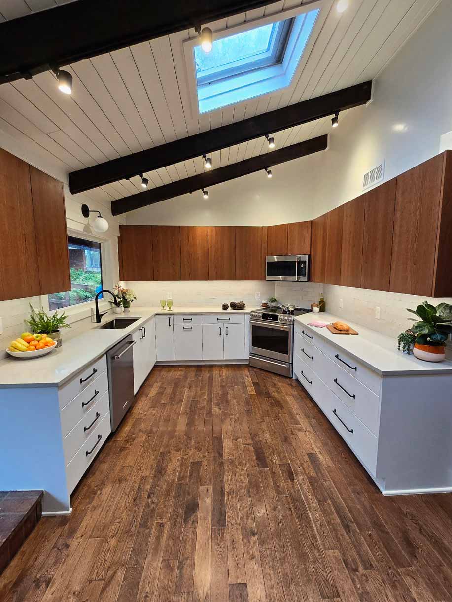 Contemporary kitchen with white lower cabinets, walnut upper cabinets, wood floors, and skylight ceiling