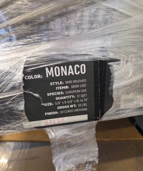 Monaco color label attached to a box containing clothing items.