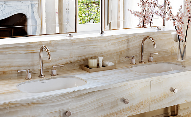 Two faucets and two sinks in a bathroom.