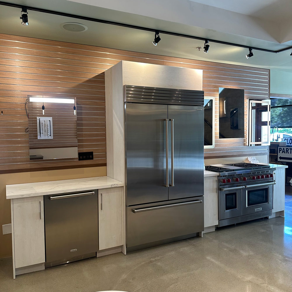 A modern kitchen featuring a stainless steel refrigerator and oven, showcasing sleek appliances and a clean design.