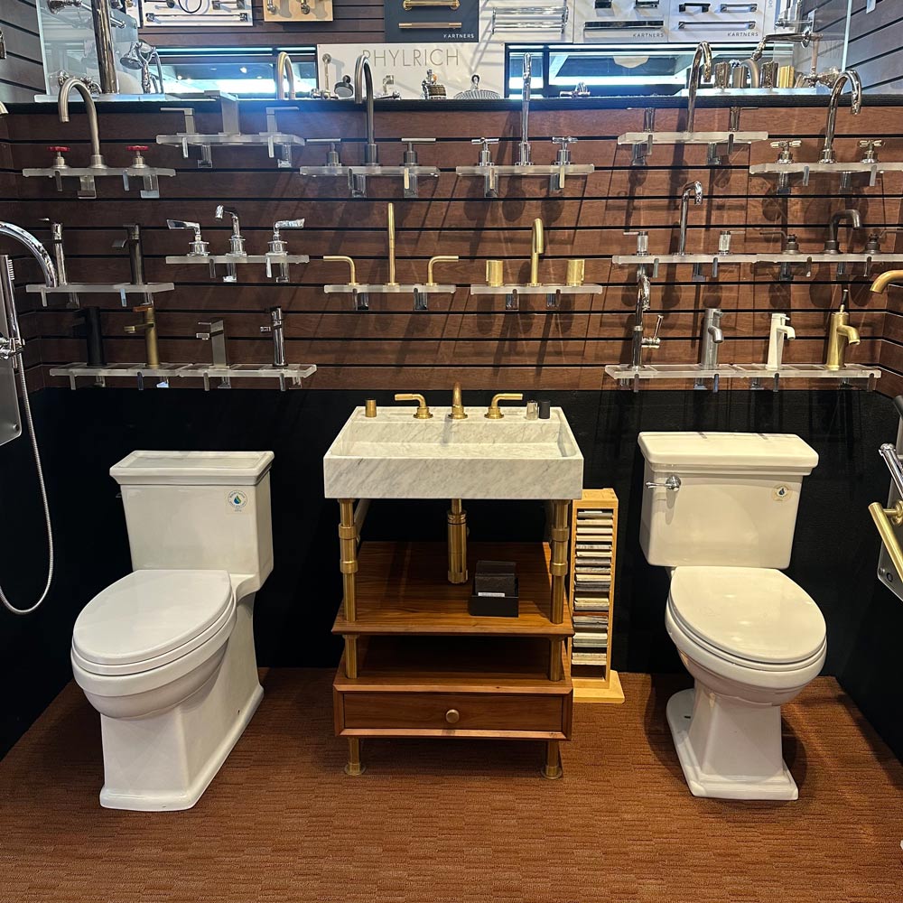 A bathroom featuring a toilet, sink, and a storage cabinet against a neutral wall.