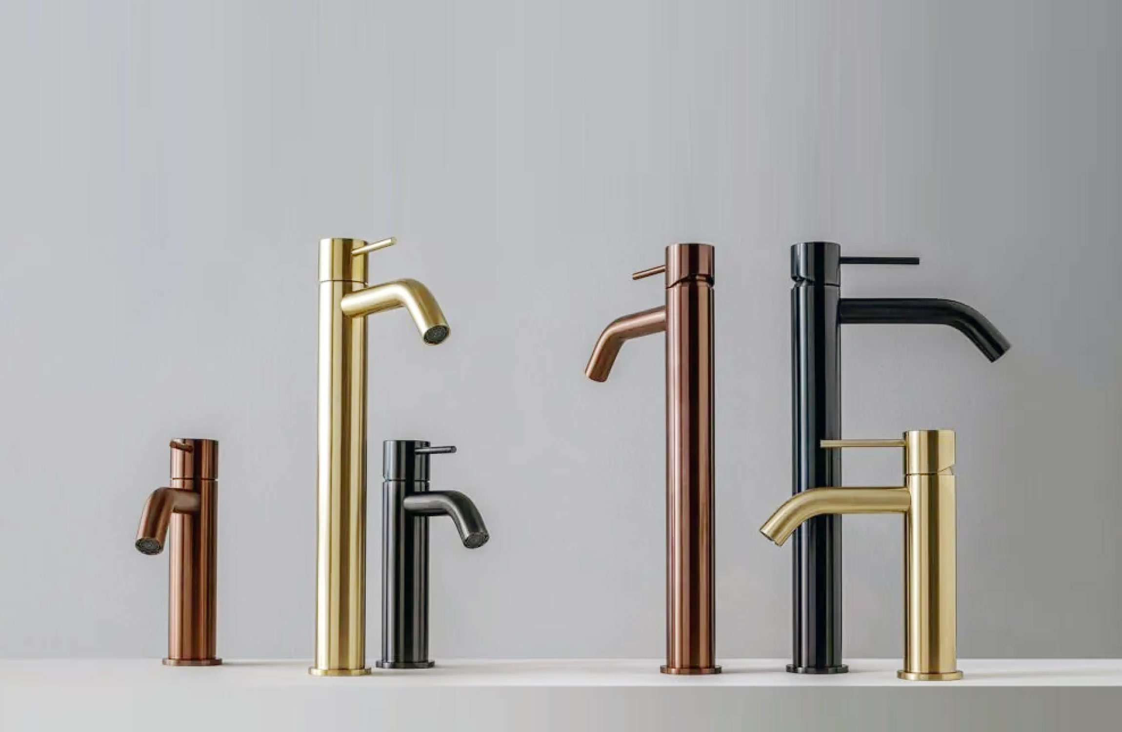 A collection of modern bathroom faucets in various finishes including gold, black, chrome, and bronze.