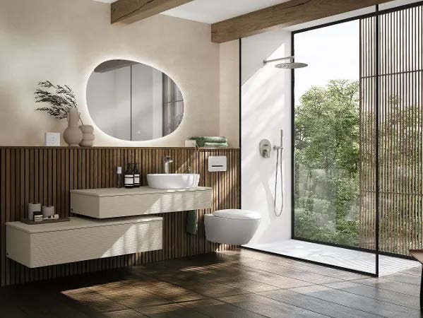 A contemporary bathroom with a round vanity mirror, a vessel sink, and a glass-enclosed shower.