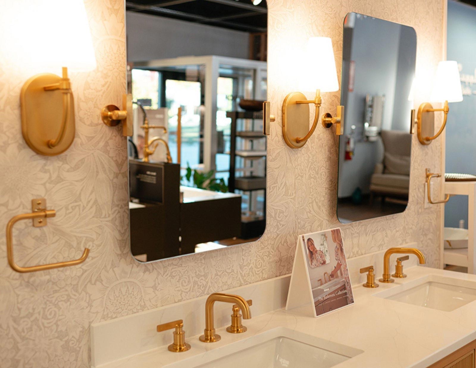 Studio McGee-designed bathroom by Kohler featuring a marble-topped vanity with brass fixtures and white shaker cabinetry