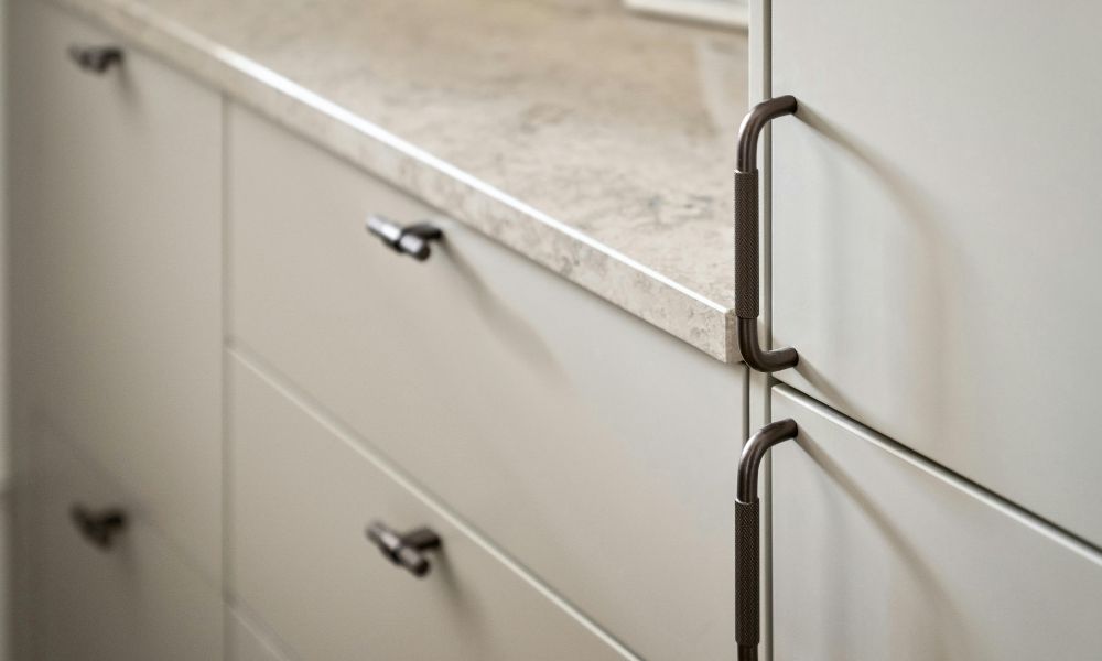 A close-up view of a kitchen cabinet featuring sleek handles, showcasing its design and finish.