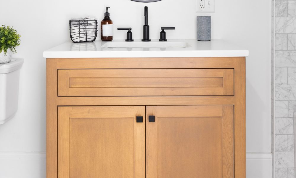 Light wood floor-mounted vanity with black hardware and white countertop