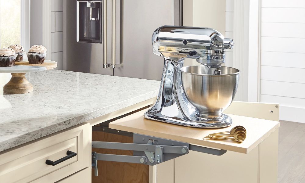 A heavy-duty stand mixer lifted to counter height on a specialized lifting platform extending from a base cabinet