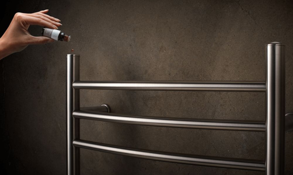 A sleek stainless steel towel warmer being used with essential oils.