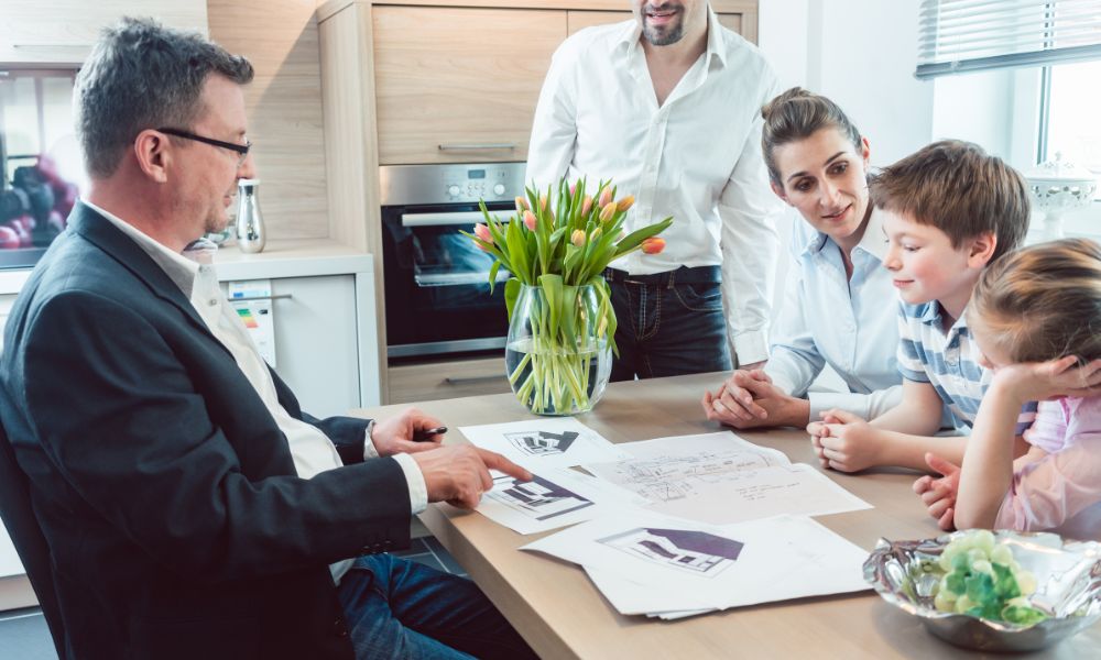 A DKB showroom consultant and client reviewing cabinet finish and material samples spread out on a table