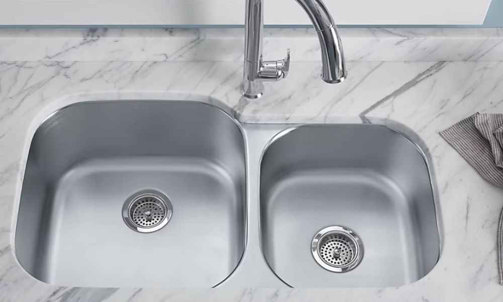 A double sink in a kitchen featuring elegant marble countertops, showcasing a modern and stylish design.