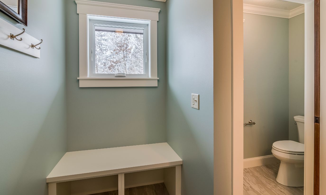 A small bathroom featuring a window, a toilet, and minimal decor, emphasizing a clean and functional design