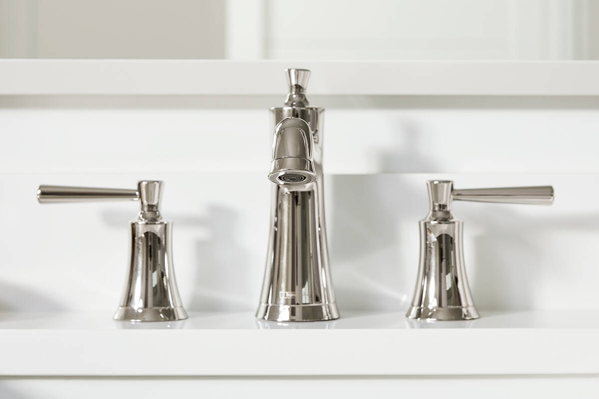 Mitigeur en bronze mat brossé, plan de lavabo blanc.